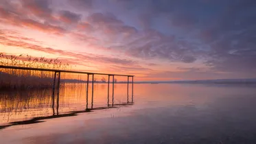 A jetty at the tranquil Lake Constance at sunrise