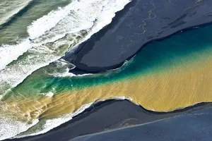 Island – Zweifarbiger Fluss mündet in Atlantik